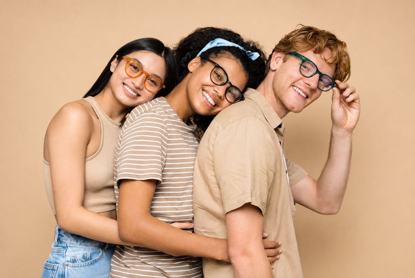 Tres amigos jóvenes con anteojos sonriendo