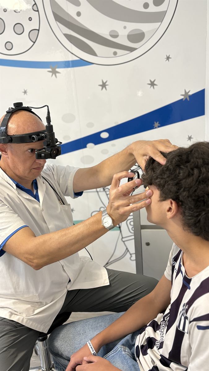 Profesional del IOC realizando un examen oftalmológico con luz frontal