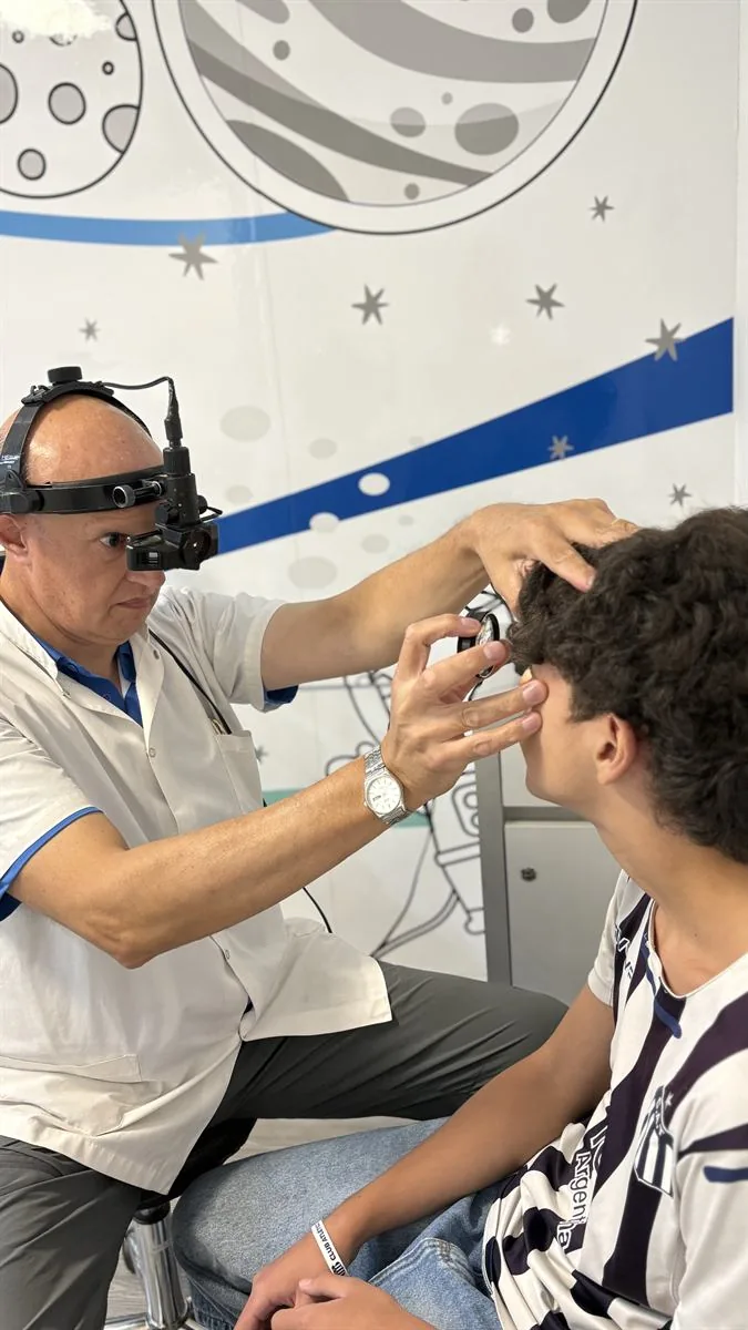 Profesional del IOC realizando un examen oftalmológico con luz frontal
